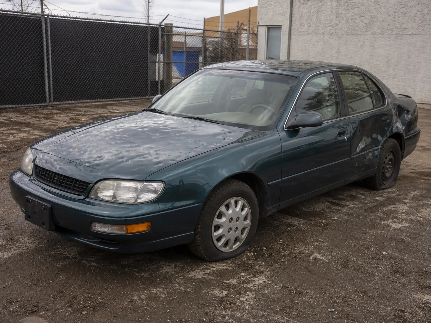 Visible collision and hail damage on a vehicle, without sensational wreckage.